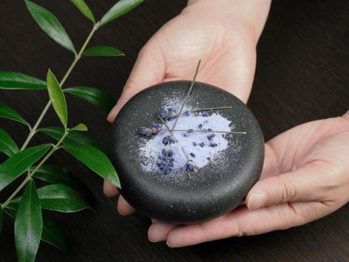 a person holding a rock with blueberries on it at Dhawa Yura Kyoto in Kyoto
