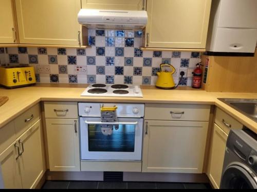 a kitchen with a white stove top oven in a kitchen at Lichfield 2-bed whole apartment in Lichfield