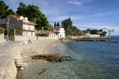 a group of people walking on a beach next to the water at Apartments by the sea Bol, Brac - 4657 in Bol