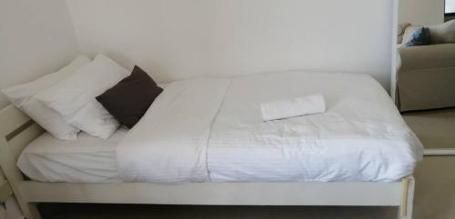 uma cama com lençóis brancos e almofadas em peace home cyberjaya em Cyberjaya
