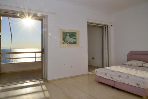 a bedroom with a bed and a view of the ocean at Anavissos Panoramic sea view apt with shared pool in Anavyssos