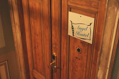 a wooden door with a sign on it at Angel Hostel in Toruń