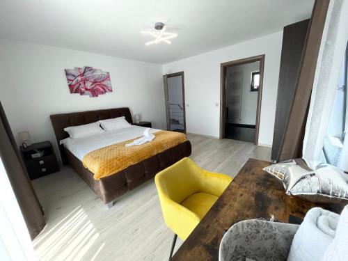 1 dormitorio con 1 cama y 1 silla amarilla en Casa Valentina en Cristian