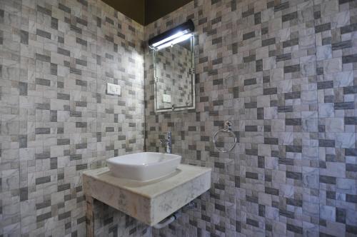 uma casa de banho com um lavatório e um espelho em River View Jungle Camp em Sauraha