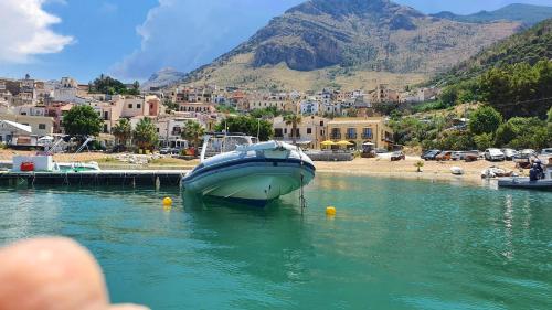 a boat is docked in a body of water at Hotel Cala Marina in Castellammare del Golfo