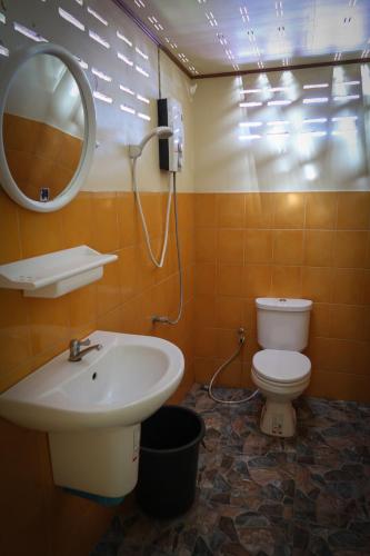 a bathroom with a sink and a toilet and a mirror at The Mermaid House in Ko Kood