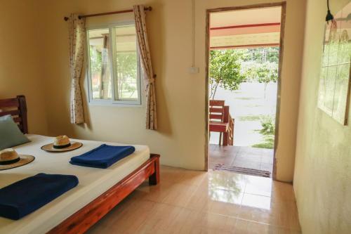 a room with a bed and a door to a patio at The Mermaid House in Ko Kood