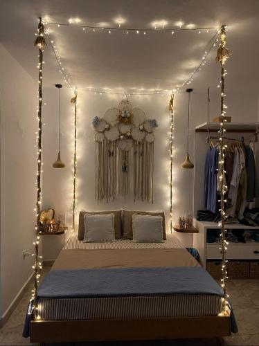 a bedroom with a canopy bed with lights at Tramonto Luxury Villa No1- Breathtaking sunset view in Karpathos Town