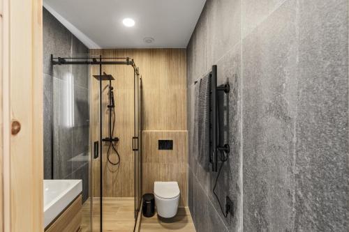 a bathroom with a shower and a toilet and a sink at Svencelės burė 8 in Svenele