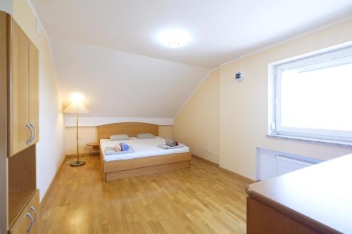 a small bedroom with a bed and a window at ITSOFT smart apartment in Komenda