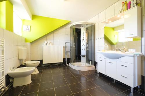 a bathroom with two toilets and a sink and a shower at ITSOFT smart apartment in Komenda