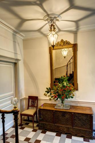 a mirror and a vase with flowers on a table at Maison de la Garenne & Spa in Vannes