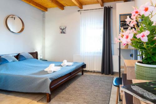 1 dormitorio con 1 cama azul y 2 toallas en Fiesta Balaton Villa, en Balatonszárszó