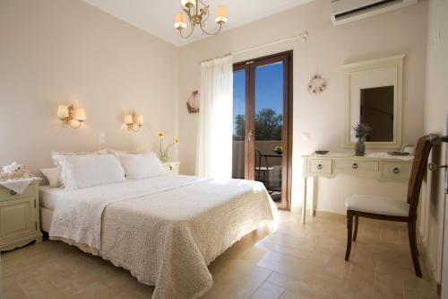 a white bedroom with a bed and a chair at Kores Villas in Nydri
