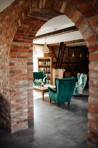 an archway in a room with chairs and a table at Folwark Pod Dębem in Nowa Karczma