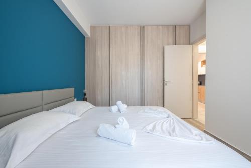 Un dormitorio con una cama blanca con toallas. en Newly renovated apt in the heart of Kerameikos, en Atenas