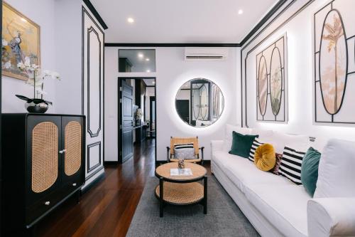 a living room with a white couch and a table at BAAN 125 STAY Phuket in Phuket Town