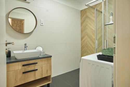a bathroom with a sink and a mirror at SUNLIGHT Silver Szeged in Szeged