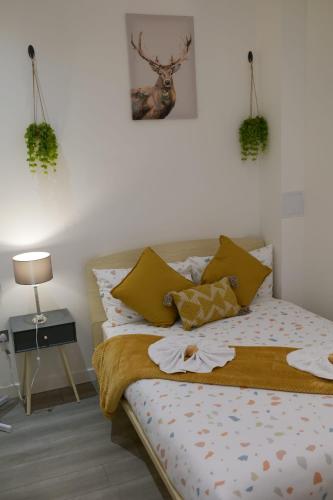 a bedroom with a bed with pillows on it at MK SHORTSTAY DELUXE-Flat 2 in Milton Keynes