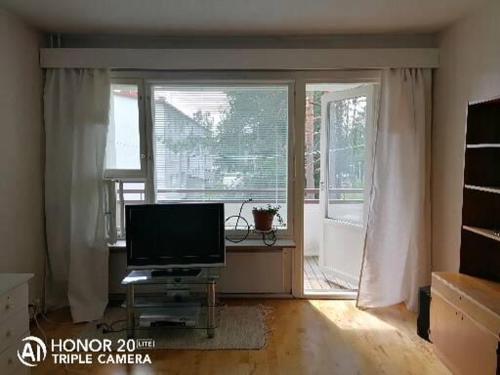 uma sala de estar com televisão e uma grande janela em Siisti valoisa kolmio em Lieksa