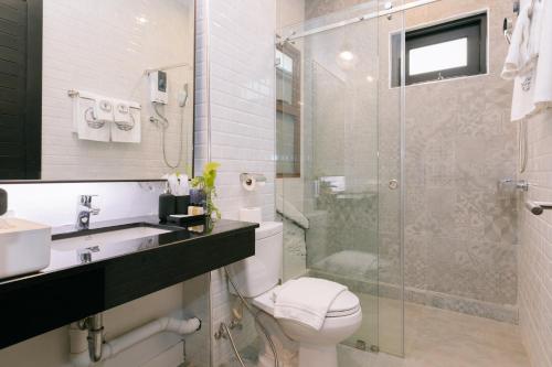 a bathroom with a toilet and a glass shower at BAAN 125 STAY Phuket in Phuket Town