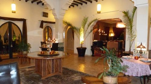a living room with a table and some plants at Riad Al Mendili Private Resort & Spa in Had Abdallah Rhiat