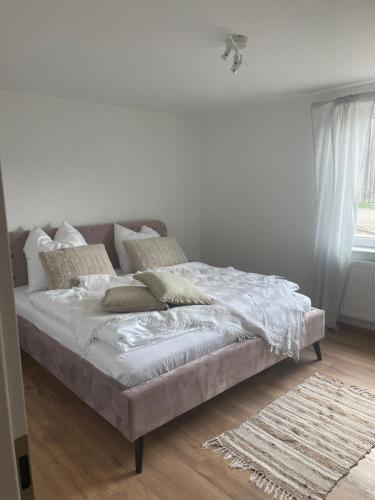 1 dormitorio con 1 cama con sábanas y almohadas blancas en Luises Ferienglück en Vernawahlshausen
