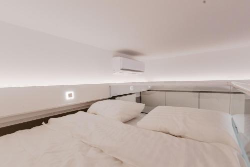 a white bed with two pillows on top of it at Võru Studio Apartment in Võru