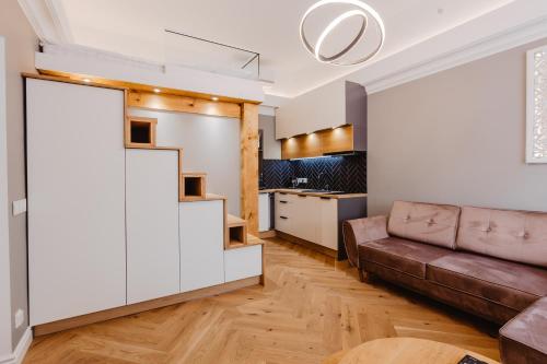 ein Wohnzimmer mit einem Sofa und einer Küche in der Unterkunft Võru Studio Apartment in Võru