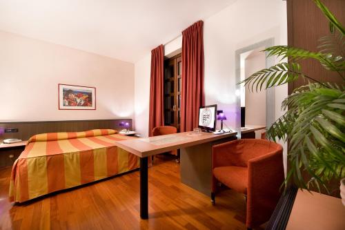 una camera con letto, scrivania e sedia di Hotel Campelli a Sondrio