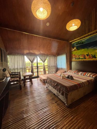 Vistapaloma beach resort في Odiong: غرفة نوم بسريرين في غرفة بها نوافذ
