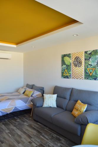 a living room with a couch and a bed at DIAMOND TORREMOLINOS TROPICAL in Torremolinos