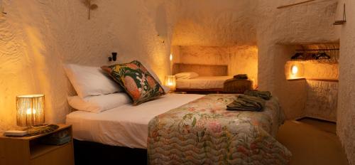 a bedroom with two beds in a room with lights at Ali's Underground Home in Coober Pedy