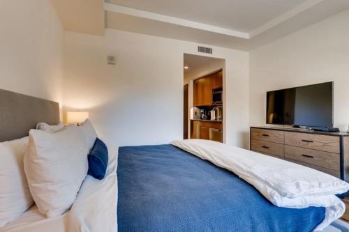 - une chambre avec un grand lit et une couverture bleue dans l'établissement Vail Lion Studio Mountain Vacation Rental Just Steps From The Eagle Bahn Gondola, à Vail
