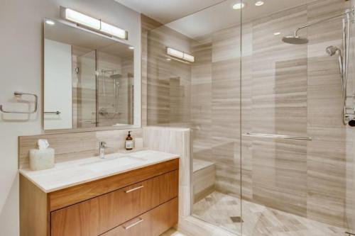 La salle de bains est pourvue d'une douche, d'un lavabo et d'un miroir. dans l'établissement Vail Lion Studio Mountain Vacation Rental Just Steps From The Eagle Bahn Gondola, à Vail