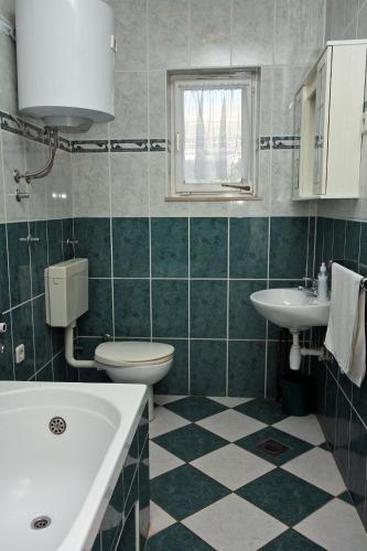 a bathroom with a sink and a tub and a toilet at Apartments with a parking space Grebastica, Sibenik - 4866 in Grebaštica