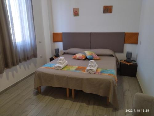 a bedroom with a bed with two dolls on it at JRG APARTMENTS in Porto Torres