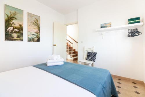 um quarto branco com uma cama com um cobertor azul em Al Rolo Beach em Málaga