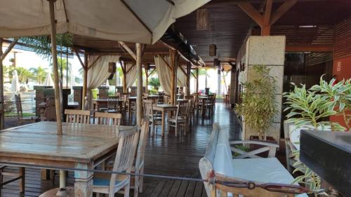 a restaurant with wooden tables and chairs and umbrellas at Apt 2 Suítes no Life Resort com Vista parcial para o Lago e lazer completo in Brasilia
