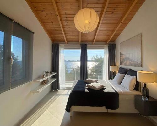 a bedroom with a large bed with a large window at Swim on a private beach in Sounio