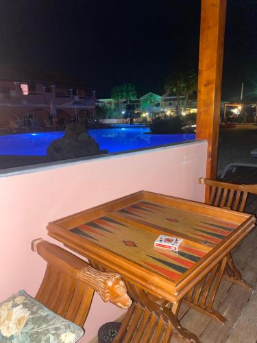 a table and two chairs on a balcony at night at Perland Vacation in Sidari