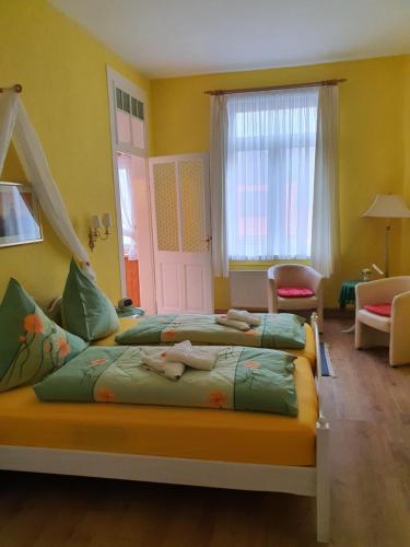Duas camas num quarto com paredes amarelas em Pension Villa Immergrün em Oberhof