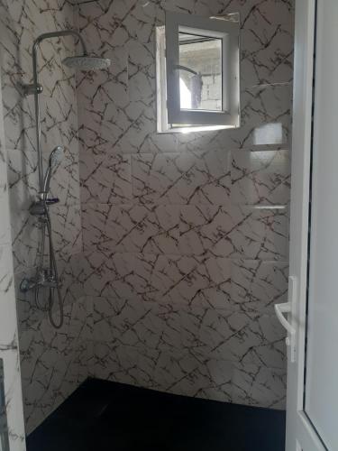 a bathroom with a stone shower with a window at kobuleti bagrationi 40 in Kobuleti