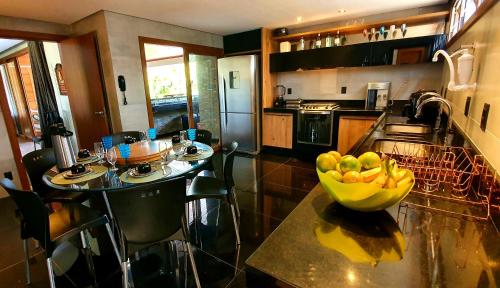 a kitchen with a bowl of fruit on a counter at 6 suítes com sofisticação e conforto na Praia do Forte! in Praia do Forte