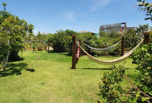 a hammock in a garden with a field of grass at 6 suítes com sofisticação e conforto na Praia do Forte! in Praia do Forte