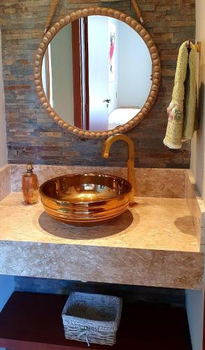 a bathroom with a wooden sink and a mirror at 6 suítes com sofisticação e conforto na Praia do Forte! in Praia do Forte