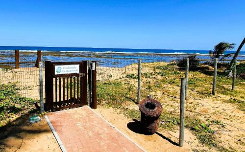 a fire hydrant in front of a gate at the beach at 6 suítes com sofisticação e conforto na Praia do Forte! in Praia do Forte