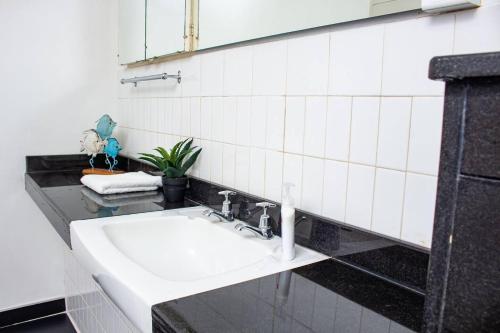a bathroom with a white sink and a mirror at Inviting 3-Bed Apartment In The City in Umtali