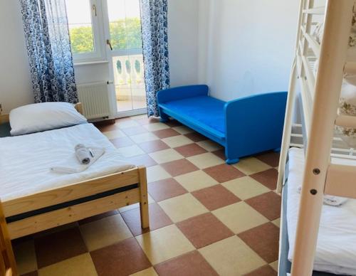 Zimmer mit 2 Etagenbetten und einem blauen Sofa in der Unterkunft ANNABERG Polanica Zdrój in Polanica-Zdrój