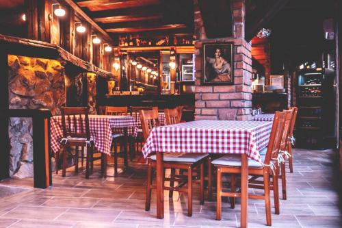 a restaurant with tables and chairs in a room at Hotel Barbizon in Nyíregyháza